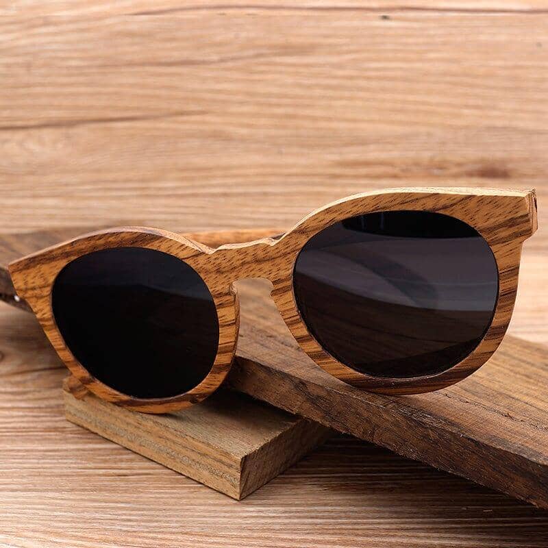 A pair of wood sunglasses over a piece of wood