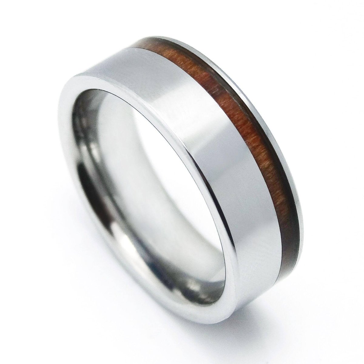 side view of a steel and wood tungsten ring on a white canvas
